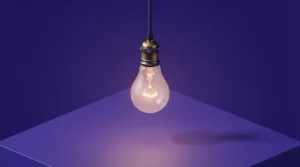 Schreibtischlampe und leuchtende Glühbirne vor einem hellen Hintergrund